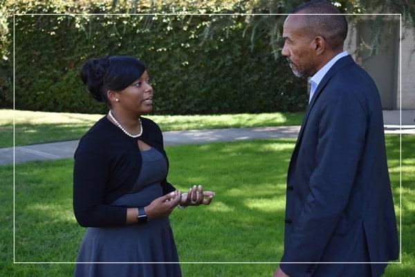 Two people in formal attire speaking outside